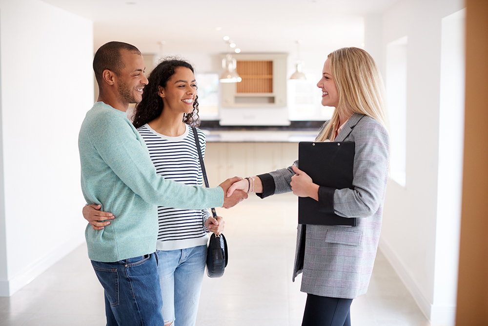 Female Realtor Shaking Hands With Couple